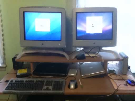 John Hatchett's computer desk with PowerBooks and 17" Apple monitors